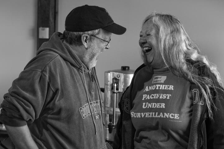 Craig and Joanne laugh together. Joanne wearing a shirt that says Another Patriot Under Surveillance