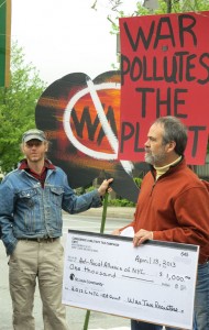 Bill and Jason with anti-war signs and a giant check of resisted war taxes