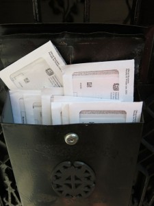 image of black mailbox with a dozen IRS envelopes sticking out the top