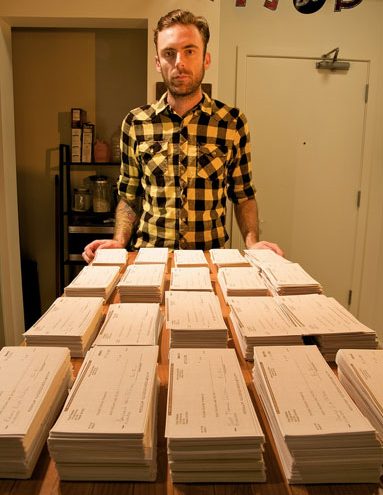 Evan Reeves behind his piles of 1-cent checks with which he paid an IRS tax bill, as a protest, in 2010.