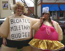 two war tax resisters in “fat suits”, one labeled 'Bloated Military Budget'