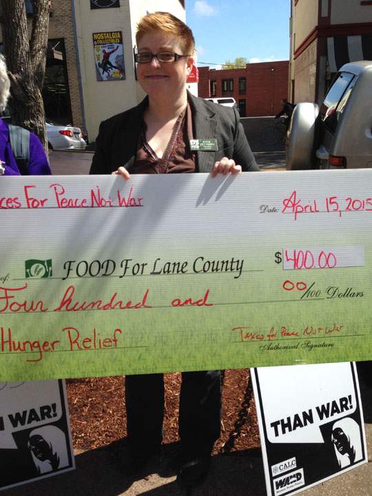 woman holding oversized check made out for $400 from “Taxes For Peace Not War” to “Food For Lane County“”