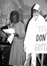 Juanita speaking next to an image of her partner Wally with a sign saying "You Don't Gotta"