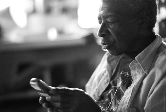 black and white photo of Juanita Nelson using a cell phone. photo by Ed Hedemann