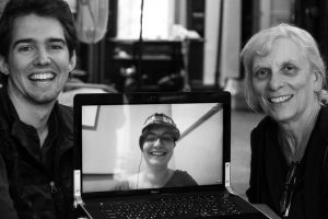 black and white photo of NWTRCC consultants, (left to right) Sam Koplinka-Loehr, Erica Weiland (on laptop screen), Ruth Benn