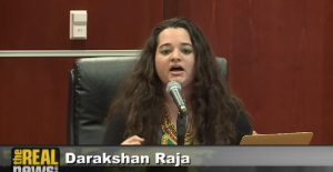 Darakshan Raja, Washington Peace Center, speaks at a microphone during the Iraq Tribunal Press Conference.