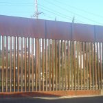 an image of the rusty brown border fence at Nogales, Sonora/Arizona, seen from the Mexican side