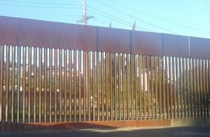 an image of the rusty brown border fence at Nogales, Sonora/Arizona, seen from the Mexican side