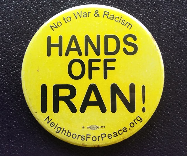 Yellow button with words "No to War & Racism- HANDS OFF IRAN- Neighbors for Peace. org