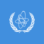 Flag of International Atomic Energy Agency with blue background, atomic particle surrounded by oak leaf branches
