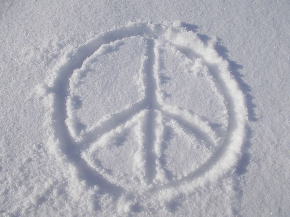 Image of a peace sign drawn in white sand