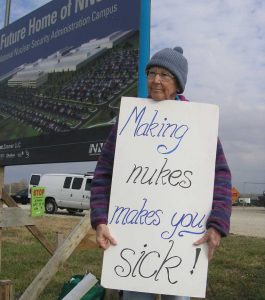 person holding a sign reading making nukes makes you sick 