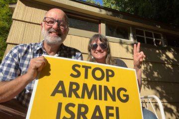 Paul and Kima holding a sign that states, "Stop Arming Israel."