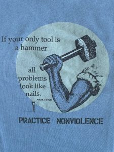 blue background with grey circle wih an arm holding a hammer with the quote 'If your only tool is a hammer all problems look like nails'