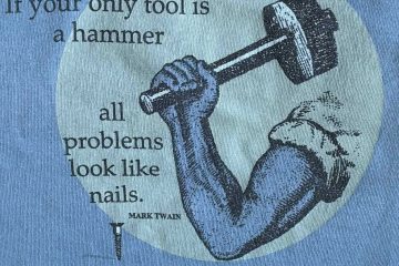 blue background with grey circle wih an arm holding a hammer with the quote 'If your only tool is a hammer all problems look like nails'